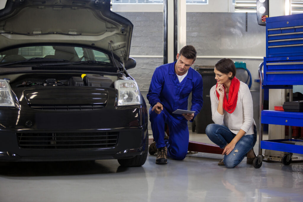 Mechanic showing customer the problem with car at the repair garage